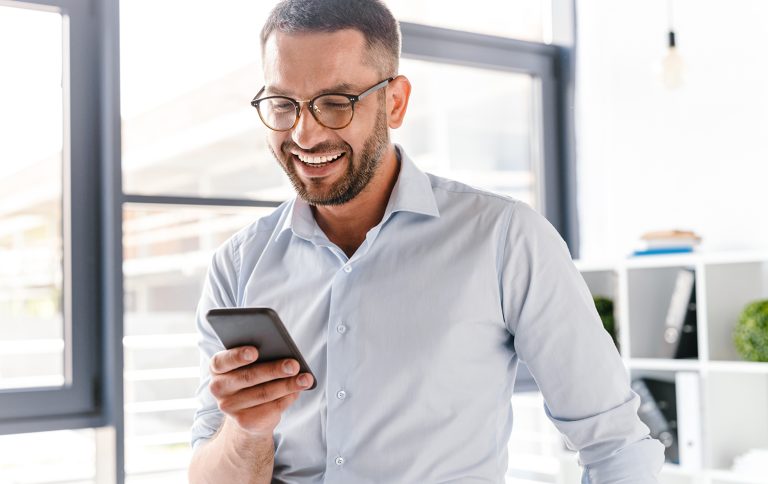 solution encaissement : homme d'affaires qui analyse ses flux de transactions depuis son téléphone